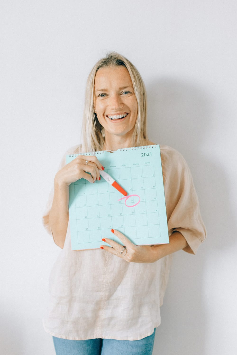 A woman standing with a pregnancy calendar
